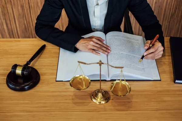 Tokmak ahşap masa ve kadın avukat ya da yargıç mahkeme tema, sözleşmede çalışma üzerinde Adalet ve hukuk kavramı.