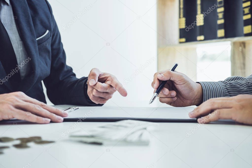 Man customer signing car document contract agreement, successful car loan contract buying or selling new vehicle and salesman pointing documents.