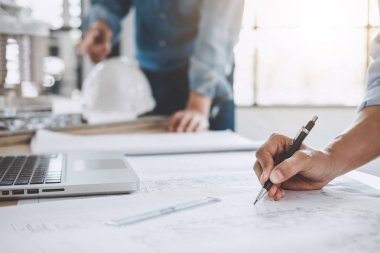 Mimar veya bina ve araçlar çalışma sitesi, inşaat kavramı içinde mühendislik modeli ortak çalışma projesi için Toplantı planı üzerinde çalışan mühendis.