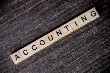 Ahşap arka plan üzerinde ahşap küpleri ile muhasebe kelimelerle bulmaca tarafından sunulan konsept.