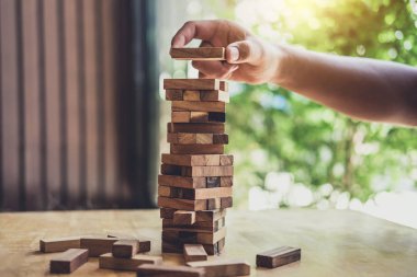 Görüntüleri el koyarak ve ahşap blok Kulesi, alternatif risk kavramı, plan ve strateji iş, Risk için yapmak iş büyüme kavramı ile ahşap bloklar çekerek iş adamları.