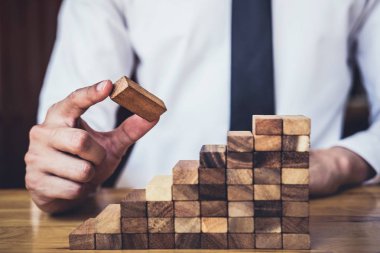 İş büyüme kavramı ile ahşap blok yapmak için riske, adamın elini kadar kazık vardır ve bir ahşap blok istifleme, alternatif risk kavramı, plan ve strateji otelde iş.