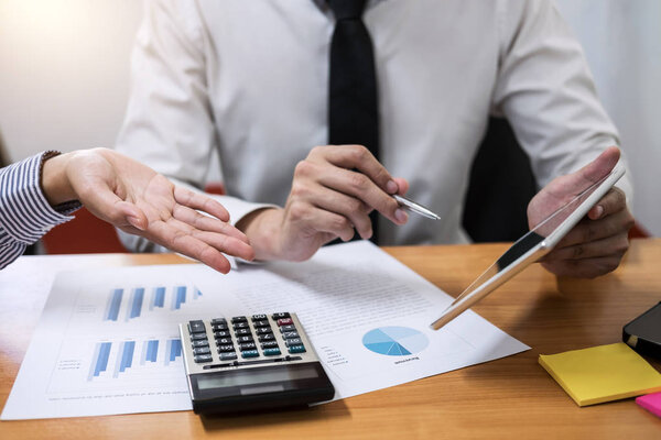 Business team meeting present, investor colleagues discussing new plan financial graph data on office table with laptop and calculator, Finance, accounting, investment.