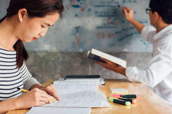 High school or college student group catching up workbook and learning tutoring in classroom and reading, doing homework and lesson practice preparing exam to entrance, education concept.