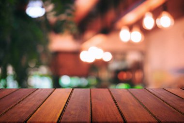Boş ahşap masa ve soyut restoran veya kahve dükkanı için ürün görüntüsünü veya montaj için önünde arka plan bulanık.
