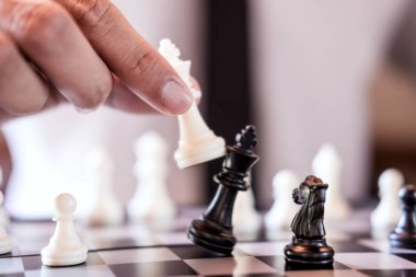 El emin işadamı kullanım Kral satranç taşını devirmek çökmesine satranç oyunu oynayan beyaz karşı takım ve geliştirme analiz yeni strateji planı, şampiyonluk ve başarı için iş stratejisi.