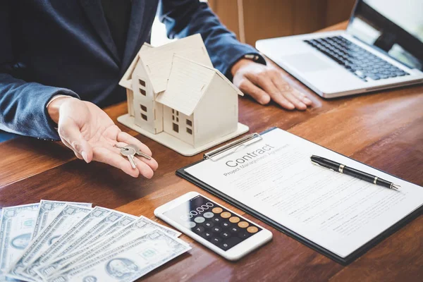 Real estate agent Sales manager holding filing keys to customer after signing rental lease contract of sale purchase agreement, concerning mortgage loan offer for and house insurance.