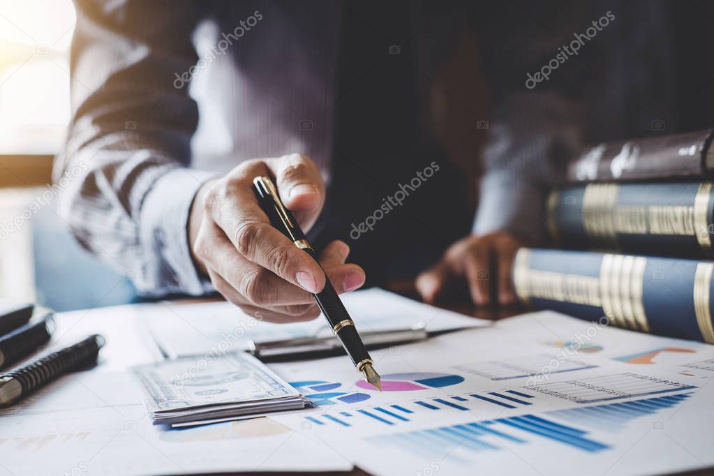 Businessman pointing at graph and chart to analysis use for plans to improve quality, business finances and accounting concept.