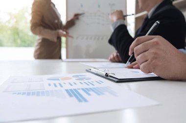 Sunu grafik gemide ve iş stratejisi için modern ofis toplantı sırasında işaret onun meslektaşları ile iş kadın lider.