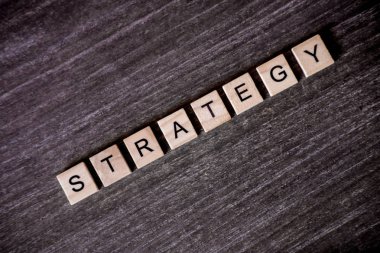 Ahşap arka plan üzerinde ahşap küpleri ile kelime strateji ile bulmaca tarafından sunulan konsept.