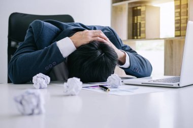 Duygu stres ve baş ağrısı, depresif ve çalışmaları sırasında tablo yüzünde gizleme yığını ile ilgili sorunlar ile sinirli onun masasında yorgun işadamı.