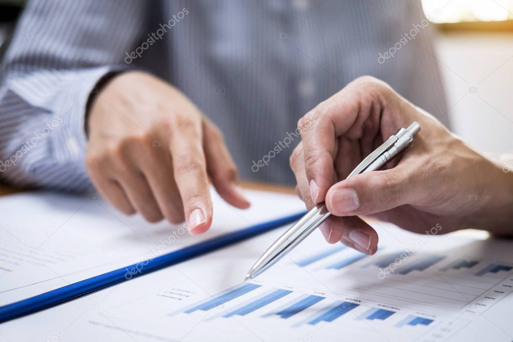 Two business team working and discussing Financial investment on report with calculate Analyze business and market growth on financial document data graph.