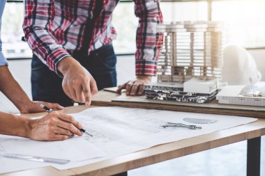 Modelleme inşaatı ve çalışma sahasında proje ortakları ve mühendislik araçlarıyla çalışmak için mühendis veya mimar toplantısı konsepti.