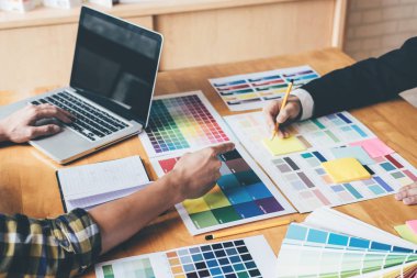 Genç yaratıcı bir toplantı yaratıcı ofis, iş araçları ve aksesuarları, renk renk örneği örnekleri grafik seçimi boyama çizim mimari sahip takım.