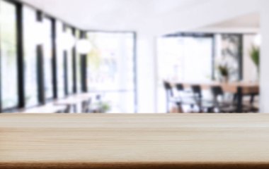 Boş ahşap masa ve kafenin ya da restoranın önündeki bulanık arkaplan ürün ya da montaj için.