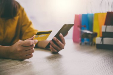 Online alışveriş web sitesi ve ödeme kredi kartı, Online ödeme ve alışveriş kavramı için akıllı telefon kullanan genç kadın görüntüsünü.