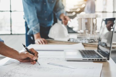 Mimar veya bina ve araçlar çalışma sitesi, inşaat kavramı içinde mühendislik modeli ortak çalışma projesi için Toplantı planı üzerinde çalışan mühendis.
