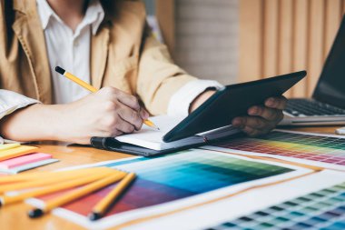 Renk renk örneği örnekleri grafik iş araçları ve aksesuarları ile stüdyoda bilgisayarla çalışırken boyama seçimi için seçmek için grafik tableti kullanarak yaratıcı grafik tasarımcı.