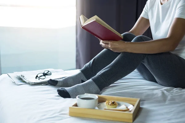 在享受读书和报纸在假日与早晨咖啡 放松和娱乐概念的年轻妇女在卧室愉快 — 图库照片