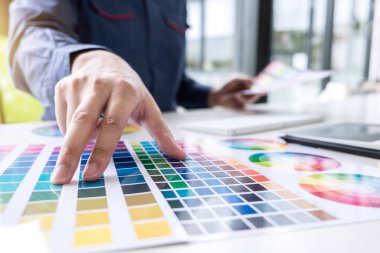 Grafik tablet iş araçları ve aksesuarları ile işyerinde çizim çalışma renk seçimi ve renk örnekleri, Erkek yaratıcı grafik tasarımcı.