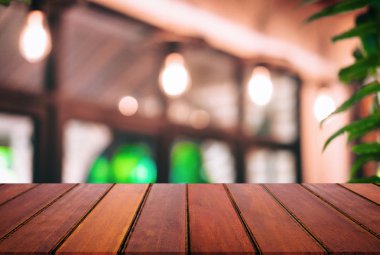 Boş ahşap masa ve kafenin ya da restoranın önündeki bulanık arkaplan ürün ya da montaj için.