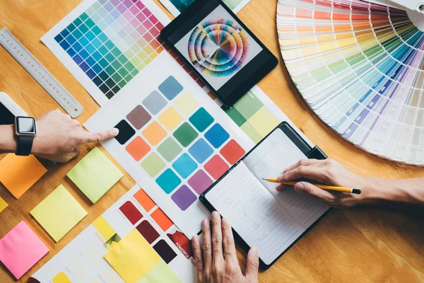 若い創造的なチームの会議をクリエイティブ オフィス 意匠図作業ツールとアクセサリー 色見本サンプルの選択色のカラーチャート — ストック写真
