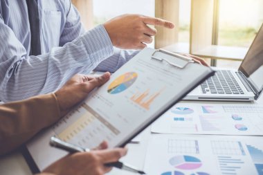 İş insanlar tartışma, Çizelgeler ve grafikler iş stratejisi ve mali plan yatırım kar için çalışıyor tartışan yönetici takımı.