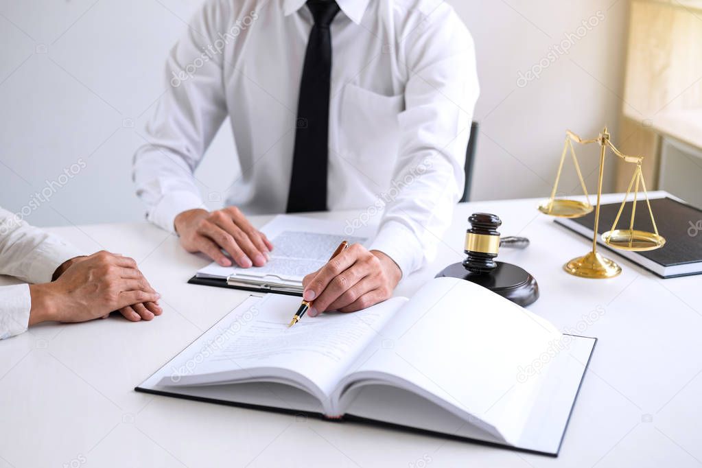 Businesspeople or lawyer having team meeting discussing agreement contract documents, judge gavel with Justice lawyers at law firm in background, Legal law, advice and justice concept.