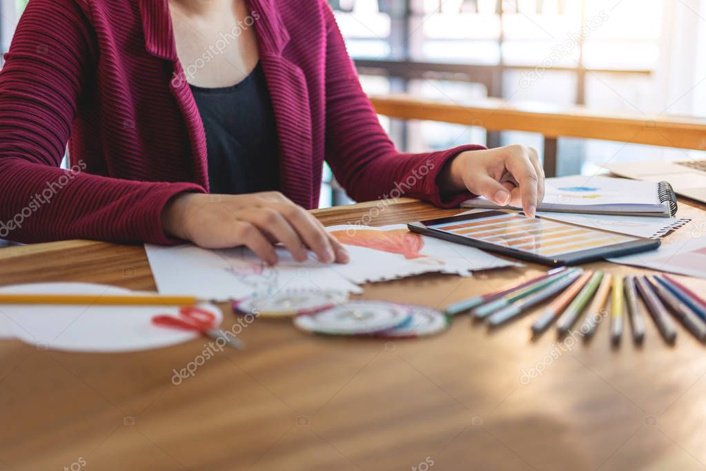 Young woman designer working as fashion designers at work with fashion sketches and color charts, profession and job occupation, Fashion Designer Stylish Concept.
