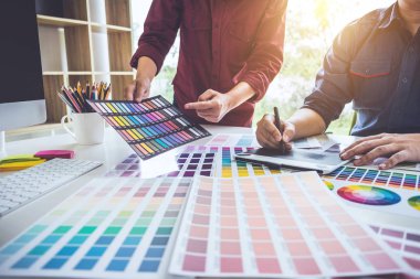 İş yerindeki grafik tabletinde renk seçimi ve çizim üzerine çalışan iki iş arkadaşı yaratıcı grafik tasarımcısı.