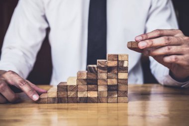 İş büyüme kavramı ile ahşap blok yapmak için riske, adamın elini kadar kazık vardır ve bir ahşap blok istifleme, alternatif risk kavramı, plan ve strateji otelde iş.
