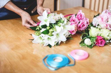 Yapay çiçek yeleği dekorasyon evde düzenlenmesi, Genç kadın çiçekçi iş DIY yapay çiçek, el sanatları ve el yapımı kavramı düzenleme yapma.
