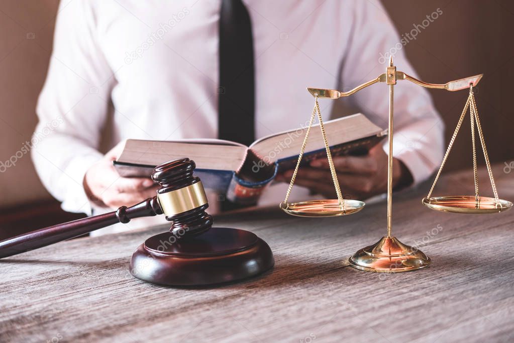 Male lawyer or judge working with Law books, gavel and balance, report the case on table in office, Law and justice concept.