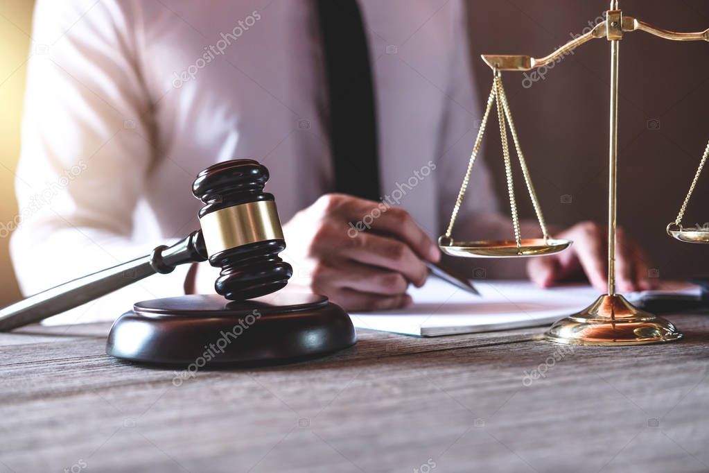Male lawyer or judge working with Law books, gavel and balance, report the case on table in office, Law and justice concept.