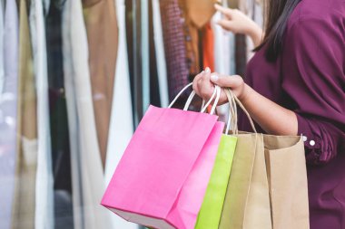 Tüketim, yaşam kavramı, renkli alışveriş torbaları holding ve moda alışveriş elbise zevk seçerek genç kadın alışveriş.