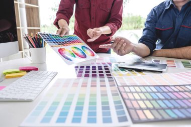 İş yerindeki grafik tabletinde renk seçimi ve çizim üzerine çalışan iki iş arkadaşı yaratıcı grafik tasarımcısı.