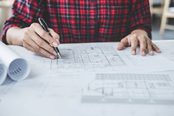 Construction and structure concept, Hands of architect or engineer working for new project plan on blueprint, model building and engineering tools in working site.