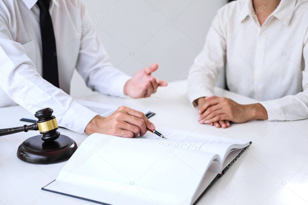 Businesspeople or lawyer having team meeting discussing agreement contract documents, judge gavel with Justice lawyers at law firm in background, Legal law, advice and justice concept.