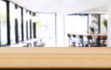 Boş ahşap masa ve kafenin ya da restoranın önündeki bulanık arkaplan ürün ya da montaj için.