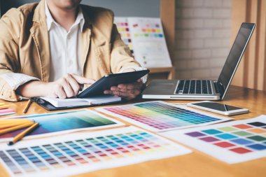 Renk renk örneği örnekleri grafik iş araçları ve aksesuarları ile stüdyoda bilgisayarla çalışırken boyama seçimi için seçmek için grafik tableti kullanarak yaratıcı grafik tasarımcı.