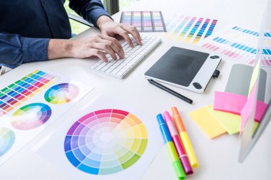 Grafik tablet iş araçları ve aksesuarları ile işyerinde çizim çalışma renk seçimi ve renk örnekleri, Erkek yaratıcı grafik tasarımcı.