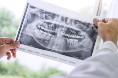 Erkek doktor ya da basılı tutup diş röntgen seyir dişçi görüntü.