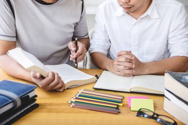 Lise öğretmeni ya da üniversite öğrenci grubu kütüphanede oturmuş ders çalışıyor, ödev yapıyor ve ders çalışıyor giriş, eğitim, öğretim, öğrenim konseptine hazırlanıyor..
