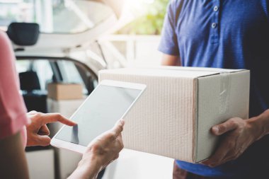 Dijital tablet imza ekleme ve bir karton kutu koli teslimat hizmeti kurye, eve teslim hizmet ve hizmet zihin ile çalışma alma kadın müşteri.