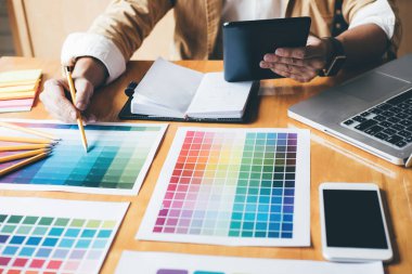 Genç yaratıcı grafik tasarımcı renk renk örneği örnekleri grafik iş araçları ve aksesuarları işyerinde boyama seçimi için seçmek için grafik tablet kullanma.