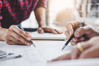 Mimar veya inşaat ve mühendislik araçları çalışma sitesi, inşaat ve yapı kavramı model üzerinde ortak çalışma projesi için toplantı planı üzerinde çalışan mühendis.