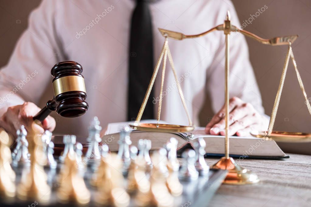 Legal law, advice and justice concept, Professional male lawyers working on courtroom sitting at the table and signing papers with gavel and Scales of justice.