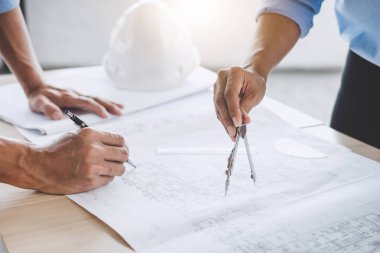 Mimar veya bina ve araçlar çalışma sitesi, inşaat kavramı içinde mühendislik modeli ortak çalışma projesi için Toplantı planı üzerinde çalışan mühendis.