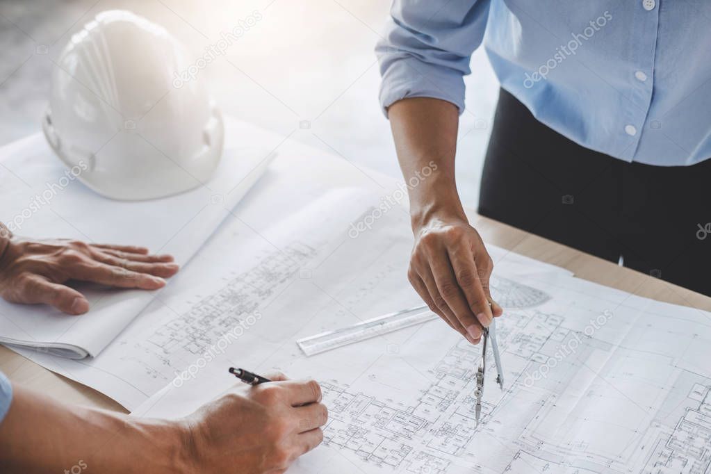 Construction concept of Engineer or architect meeting for project working with partner and engineering tools on model building and blueprint in working site.