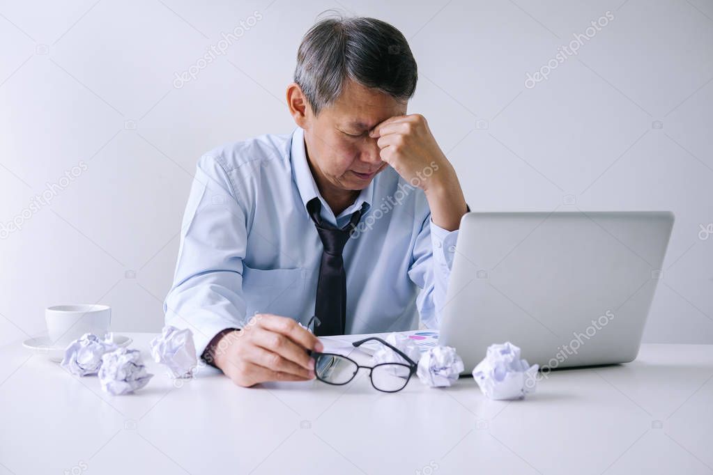 Feeling sick and tired, Senior businessman depressed and exhausted, businessman at his desk frustrated with problems and keeping eyes closed while sitting on office.